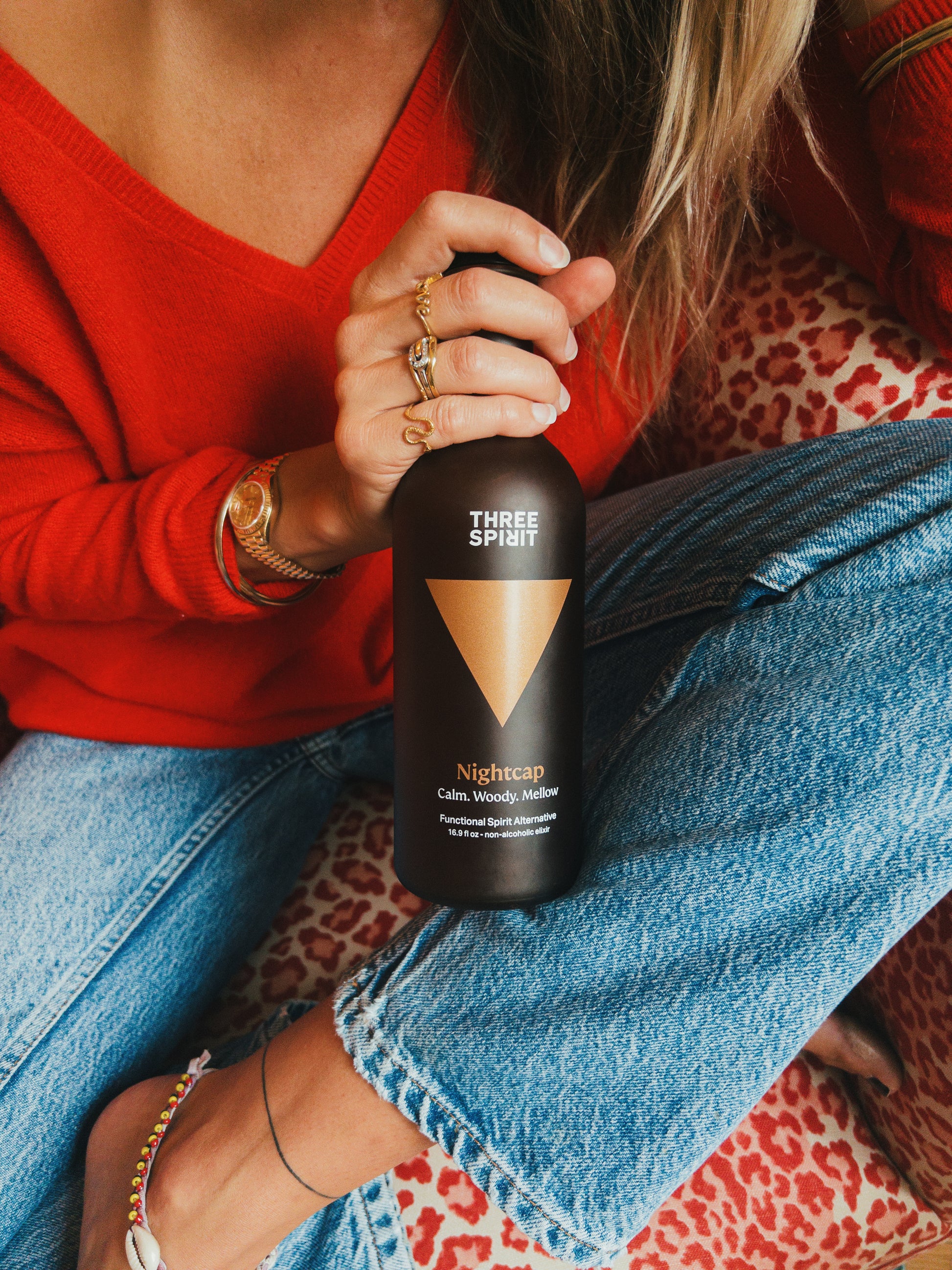 Three Spirit Nightcap bottle being held by female but her head doesn't show