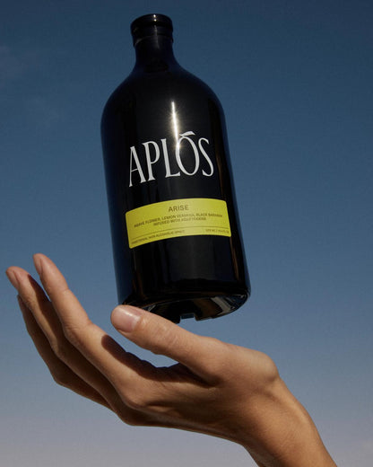 Aplos Arise bottle being held in sky by woman hand