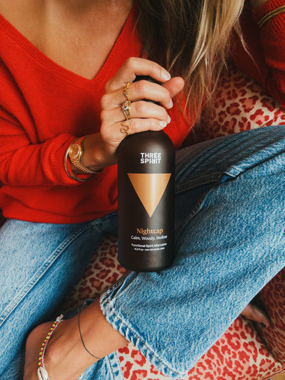 Three Spirit Nightcap bottle being held by female but her head doesn't show