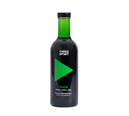 A bottle of Three Spirit Social Elixir, a non-alcoholic botanical spirit with a dark label featuring green text.