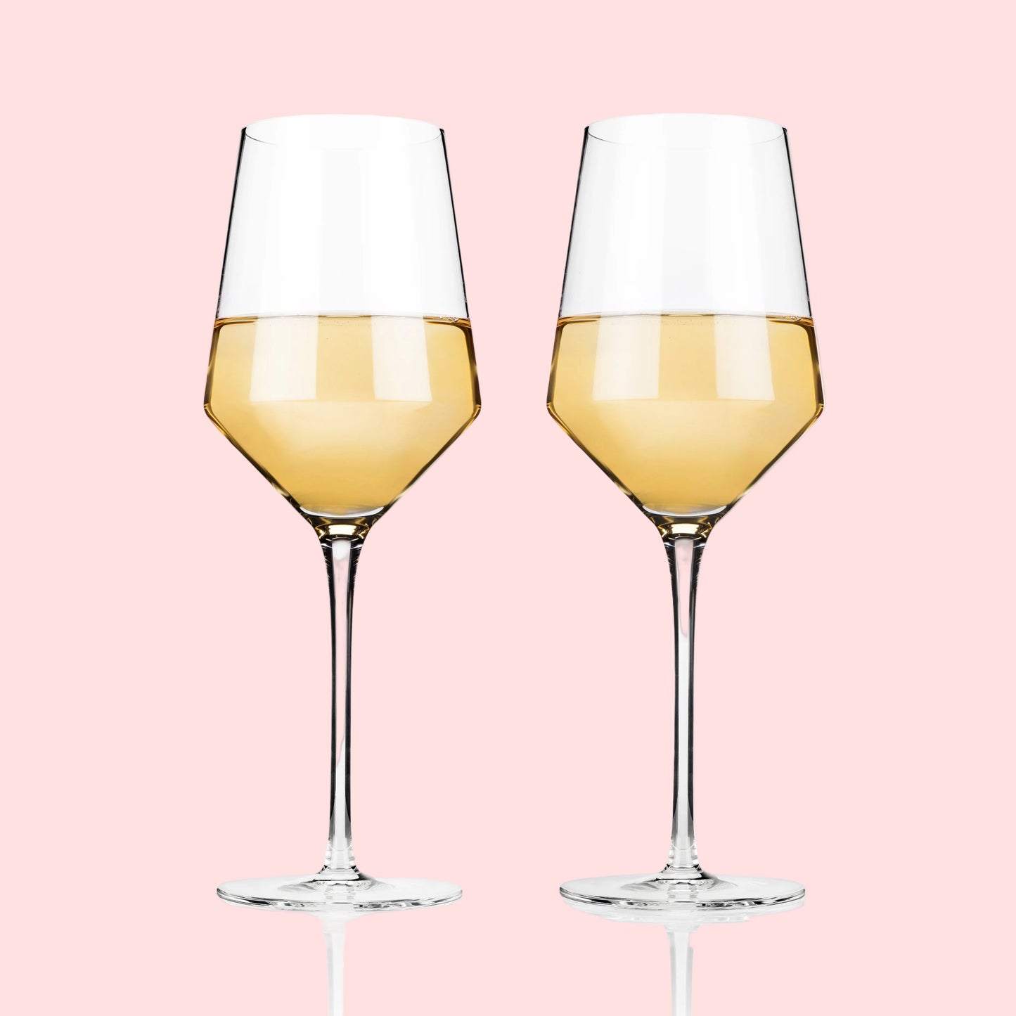 Two wine glasses filled with white wine on a white background