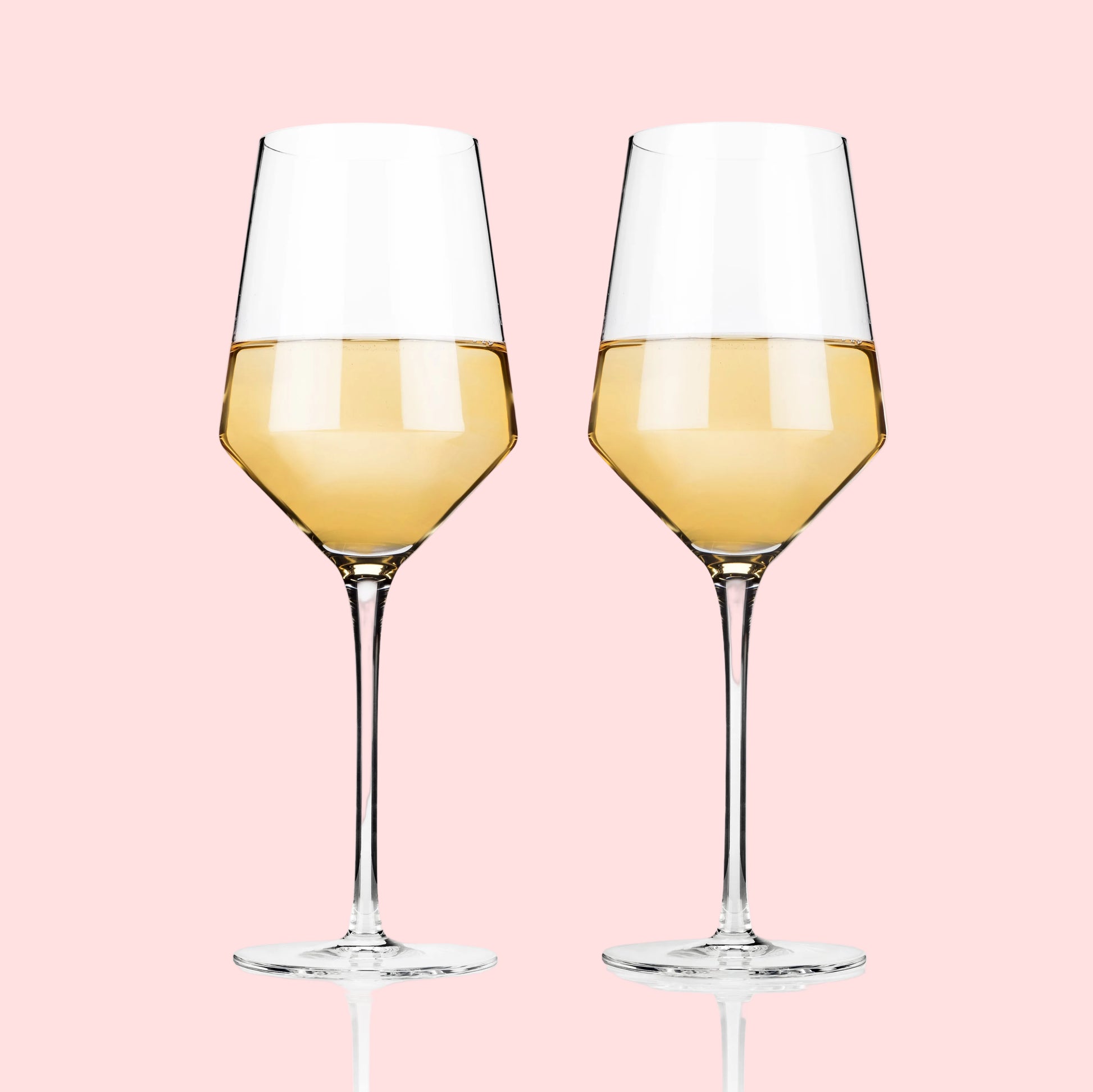 Two wine glasses filled with white wine on a white background